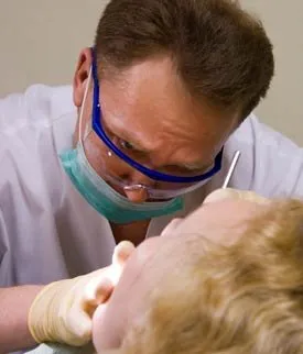 Doctor examining a patient's dentures as part of routine maintenance